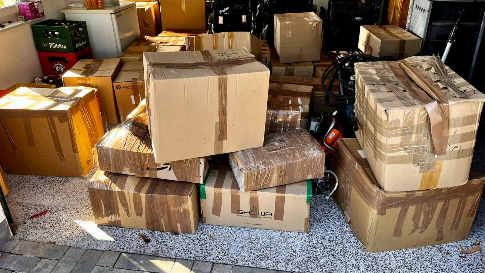 Viele zugeklebte Umzugskartons und Rollstühle in einem Raum.