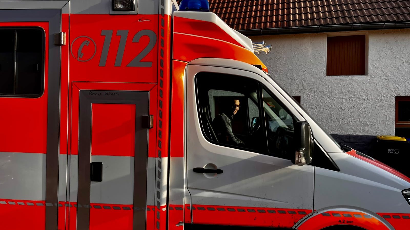 Seitenansicht eines rot-weißen Rettungswagens mit der Aufschrift 112.